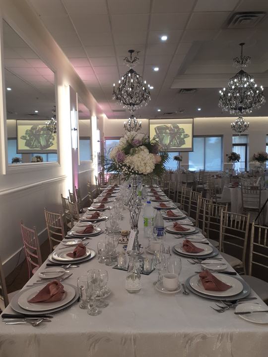 Long banquet table, pink napkins, chandeliers