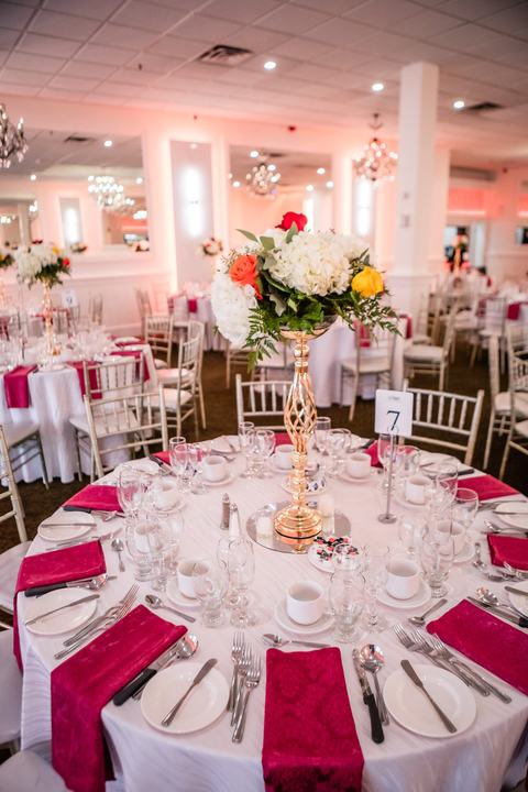 Table setting red napkins gold centerpiece