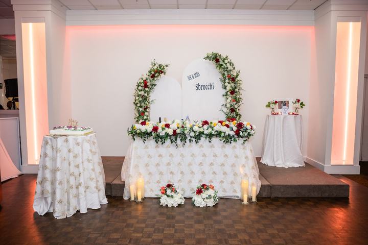 Head table with floral arches and 'Mr & Mrs Sbrocchi' arch panels