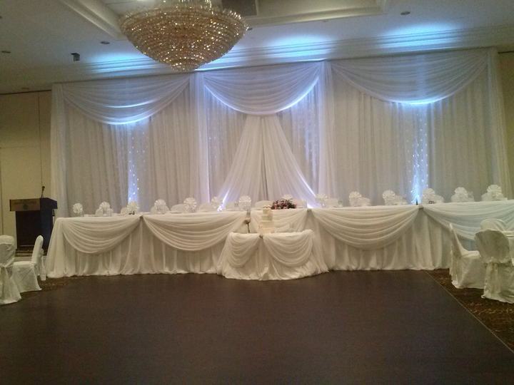 Head table white swag drapery backdrop, uplighting