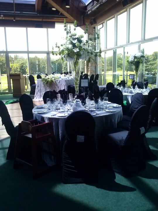 Sunroom tables, black chair covers, tall florals