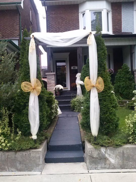 House front: draped tulle arch with gold bows