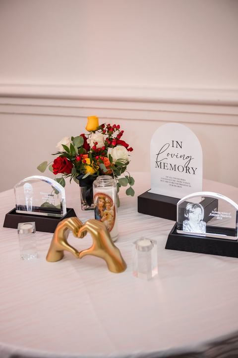 Memorial table: crystal plaques, florals, gold heart hands