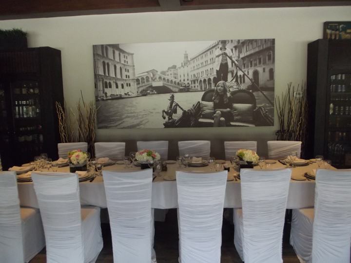 Private room long table with ruched chair covers and a Venice mural
