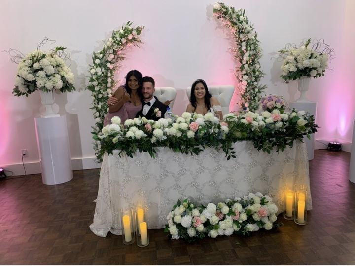 Couple and guests at the head table with floral half-arches