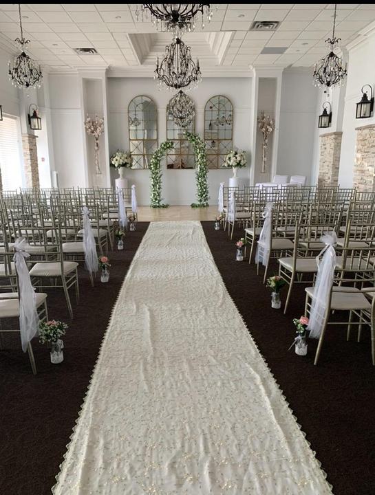 Ceremony room aisle runner, chair florals, arch