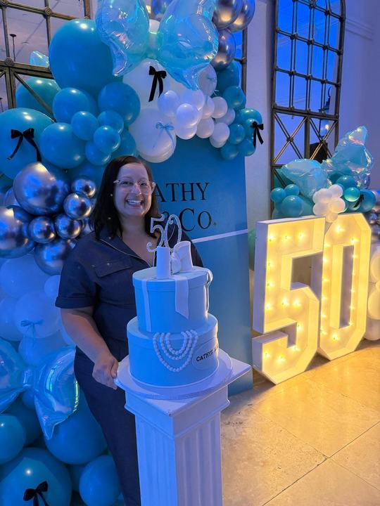 50th birthday cake with a teal balloon garland and marquee numbers