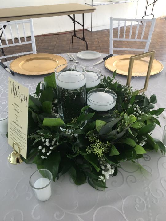 Greenery wreath floating candles centerpiece, gold chargers, menu
