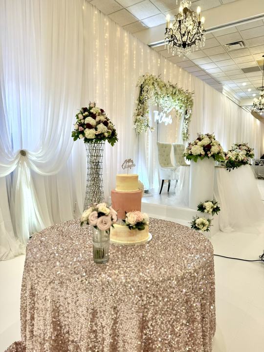 Sequin cake table, two-tier cake, floral arch behind
