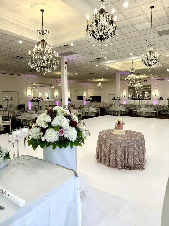 Ballroom wide: white dance floor, cake table, florals