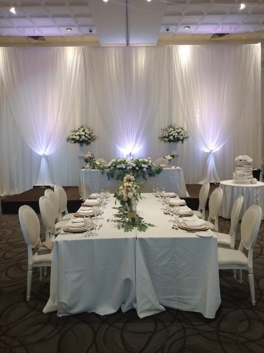 Head table drapery uplit, long table greenery