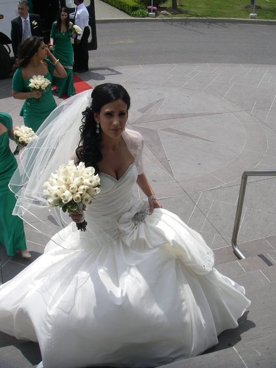 Bride with white rose bouquet, bridesmaids green