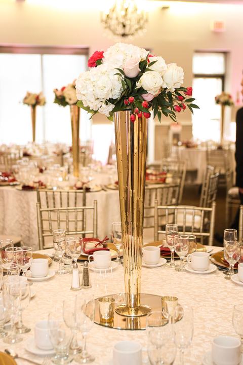 Tall gold trumpet vase centerpiece with white roses
